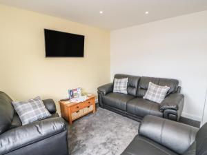 a living room with couches and a flat screen tv at Bramble Cottage in Durham