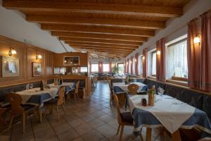 ein Restaurant mit Tischen, Stühlen und Fenstern in der Unterkunft Albergo Aurora in Vignola