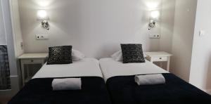 two beds in a small room with lights on the wall at Great Stay Fanqueiros 1 in Lisbon