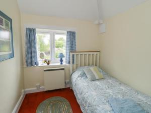 a bedroom with a bed and a window at Manor Cottage in Pickering