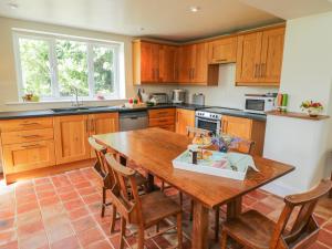 a kitchen with a wooden table and wooden cabinets at Manor Cottage in Pickering