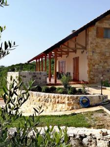 una casa con una pared de piedra delante de ella en Villa Magnolia, en Radanovići