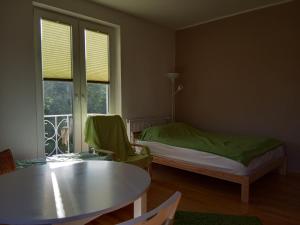 Cette chambre comprend un lit, une table et une fenêtre. dans l'établissement Apartament Monika, à Sopot