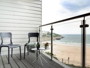 2 Stühle und ein Tisch auf einem Balkon mit Strandblick in der Unterkunft Onshore 3 in Newquay