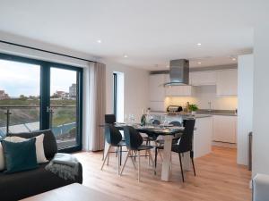 eine Küche und ein Wohnzimmer mit einem Tisch und Stühlen in der Unterkunft Onshore 3 in Newquay