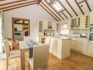 a kitchen with white cabinets and a table and chairs at The Barn at Orchard Farm in York