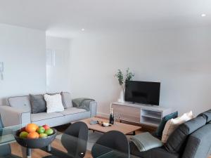 ein Wohnzimmer mit 2 Sofas und einem TV in der Unterkunft Onshore 3 in Newquay