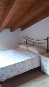 um quarto com 2 camas e um tecto de madeira em Alloggio Turistico L'Ulivo em Monte San Biagio