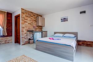 a bedroom with a bed and a brick wall at Apartments Obala in Podgorica