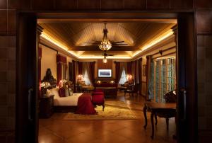 a hotel room with a bed and a living room at Coorg Wilderness Resort & Spa in Madikeri