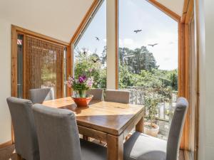 a dining room with a table and chairs and a large window at Drumhead Bothy in Banchory