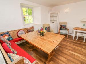 a living room with a wooden table and chairs at Polsue Cottage in Truro