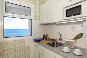 a kitchen with a sink and a window at Aparthotel Barracuda in Ponta Delgada