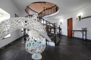 a hallway with a spiral staircase with a white sculpture at Aparthotel Barracuda in Ponta Delgada
