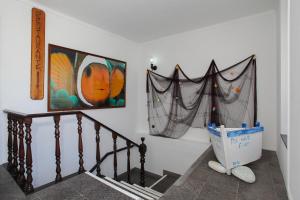 a hallway with a staircase with a painting on the wall at Aparthotel Barracuda in Ponta Delgada