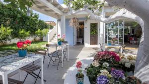 eine Terrasse mit Tischen, Stühlen und Blumen in der Unterkunft Hotel Intorno Al Fico in Fiumicino