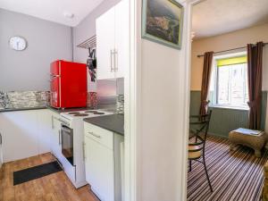 a kitchen with a red refrigerator and a table at River Cottage in Port Talbot +13 photos
