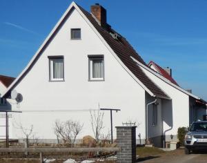 a white house with a car parked in front of it at Ferienwohnung Seestern Ückeritz in Ueckeritz