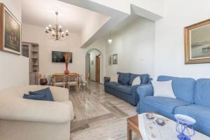 ein Wohnzimmer mit blauen Sofas und einem Tisch in der Unterkunft Villa Bloom in Vourvoúlos