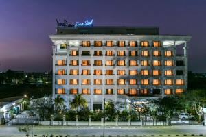 un edificio de hotel con un cartel de neón encima en Sun-n-Sand Shirdi, en Shirdi