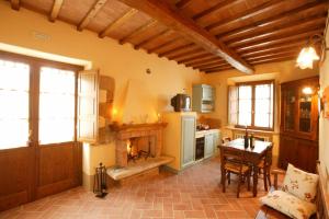 uma cozinha com uma mesa e uma lareira em Agriturismo Podere San Gregorio em Pienza