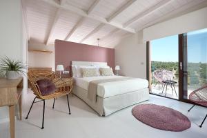 a bedroom with a white bed and a large window at Villa Niolos II in Stérnai