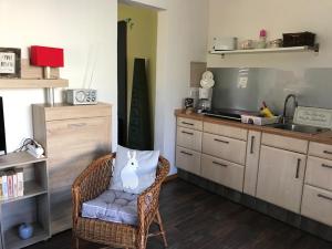 eine Küche mit einem Korbstuhl und einer Spüle in der Unterkunft Helenes Ferienwohnung auf dem Bauernhof - Lausitzer Seenland in Laubusch