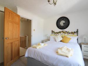 een slaapkamer met een groot wit bed met gele kussens bij Breydon Cottage in Great Yarmouth