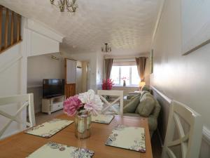 sala de estar con mesa y sofá en Breydon Cottage, en Great Yarmouth