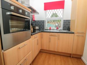 a kitchen with wooden cabinets and a window at 10 Reivers Gate in Morpeth