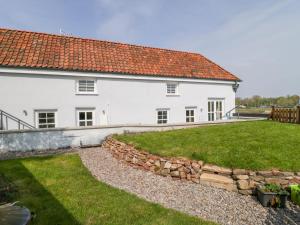 a large white house with a stone wall at Avonside Cottage in Bristol