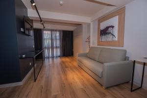 a living room with a couch and a television at Apartamentos Puerta de Llanes in Llanes
