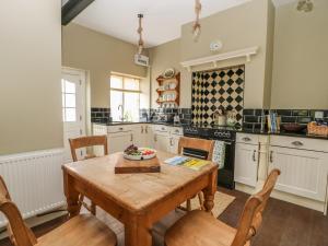 a kitchen with a wooden table and chairs at Warren House Cottage in Market Rasen