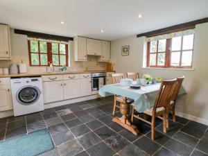 a kitchen with a table and chairs and a washing machine at Thorny Tallet in Okehampton