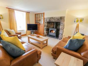 a living room with two couches and a fireplace at Llety Perygl in Harlech