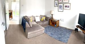 ein Wohnzimmer mit einem Sofa und einem TV in der Unterkunft Home Crowd Luxury Apartments- Auckley House in Doncaster