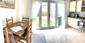a kitchen with a wooden table and a kitchen with a door at Home Crowd Luxury Apartments- Auckley House in Doncaster