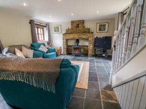 a living room with a blue couch and a fireplace at Thorny Tallet in Okehampton
