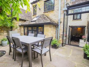 a table and chairs in front of a building at Murton Cottage in Burford