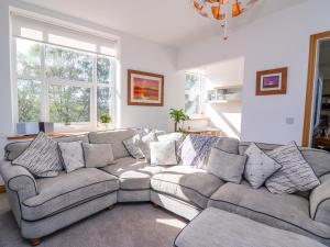 a living room with a gray couch with pillows at Ty'r Orsaf in Builth Wells