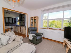 sala de estar con sofá, silla y TV en Ty'r Orsaf en Builth Wells