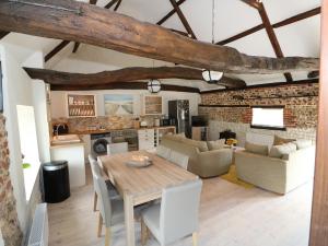 a kitchen and living room with a wooden table and chairs at Far Barn in Fakenham