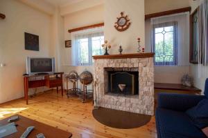 a living room with a fireplace and a tv at Laconian Collection #Karvela's stone house# in Karvelás