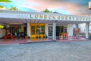 een winkel met een gele deur en rode krukken bij OYO 1206 Lombok Guest House in Mataram
