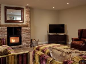 a living room with two couches and a fireplace at 67 Bridge End in Warwick