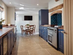 a kitchen with blue cabinets and a table with chairs at 67 Bridge End in Warwick