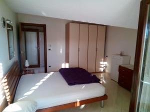 a bedroom with a large white bed and a mirror at Attico Mansardato e Climatizzato con vista Mare in Montesilvano