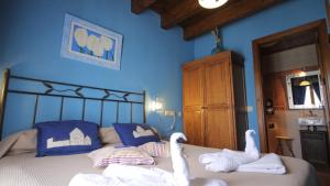 Alojamientos rurales Angelita في Olocau del Rey: اثنين من البجعات جالسين على سرير في غرفة النوم
