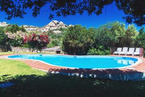 a swimming pool in a yard with mountains in the background at Domus Liscia di Vacca in Liscia di Vacca