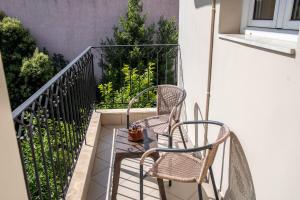 two chairs and a table on a balcony at Guesthouse Nefeli in Litochoro